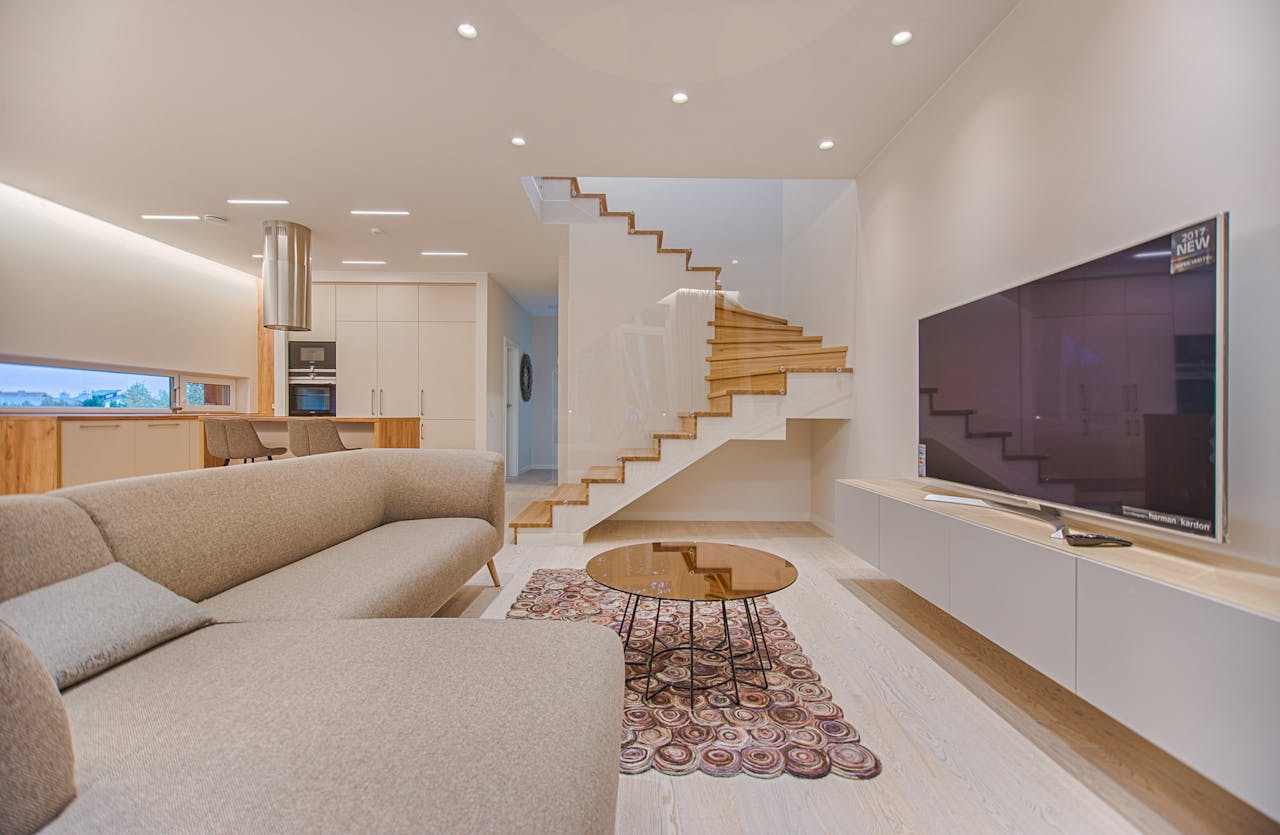 creative-02 Spacious modern living room featuring stairs, a TV, and sleek furniture design.