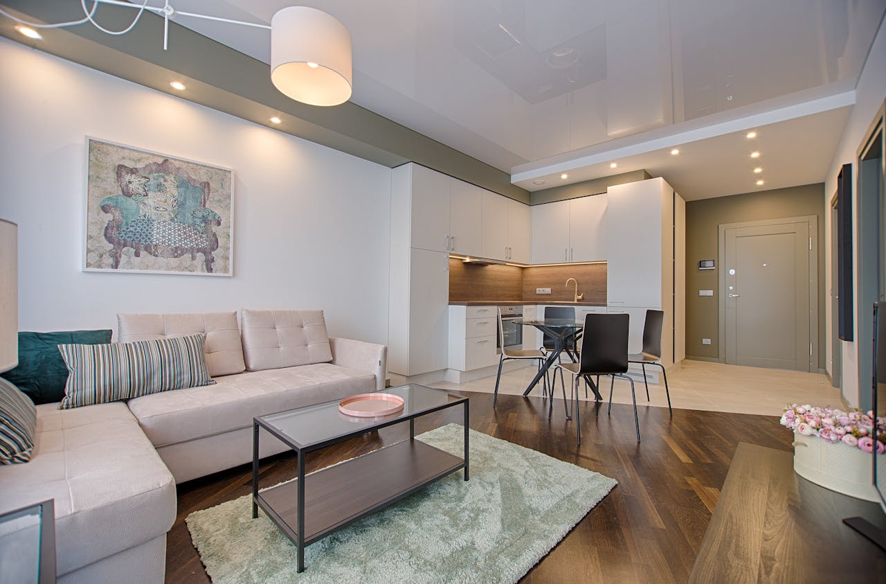 Services-02 Spacious modern living room featuring chic furniture, stylish decor, and a minimalist kitchen.