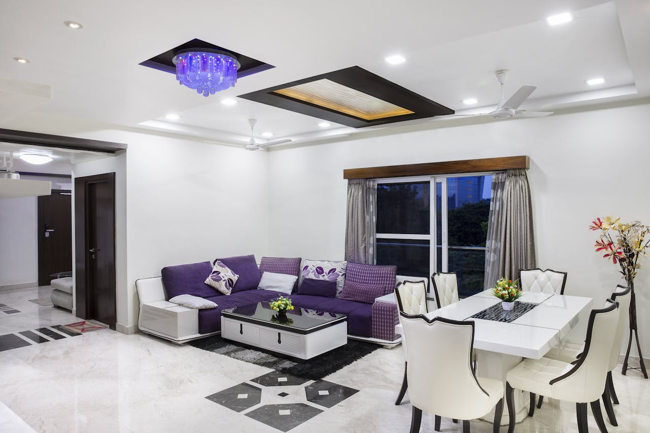 brand-01 Elegant living room with modern decor, featuring a purple sofa and chic dining area.