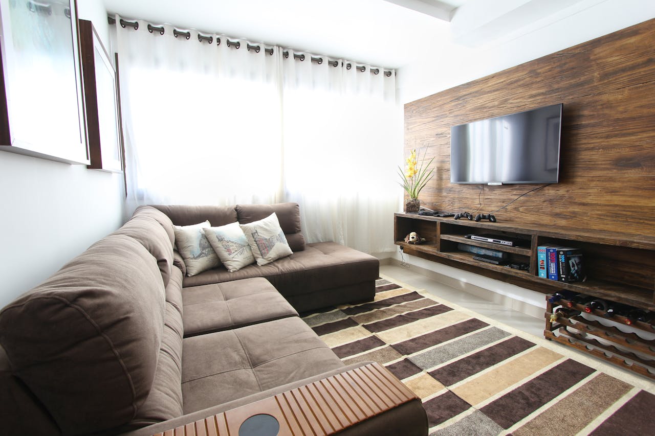 brand-03 Stylish modern living room featuring a brown sofa, wall-mounted TV, and interior decor.